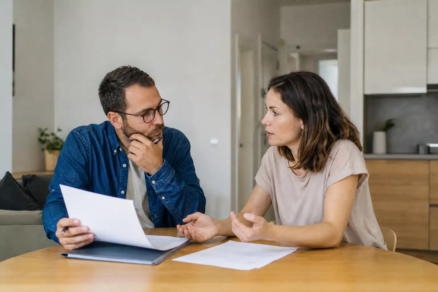 Couple discutant de documents à table